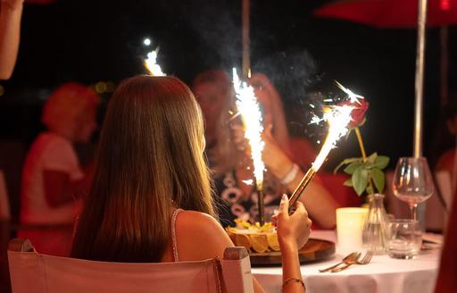 Lady sitting at table holding fireworks