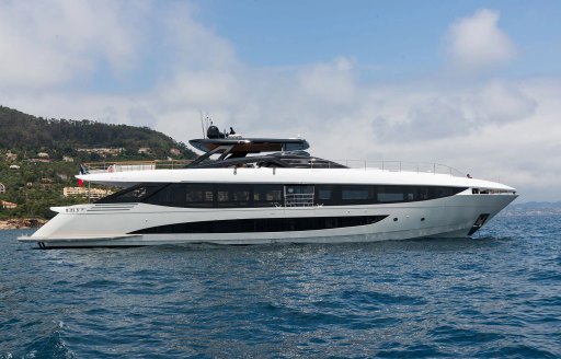 Charter yacht LAFAYETTE at anchor with elevated terrain in background