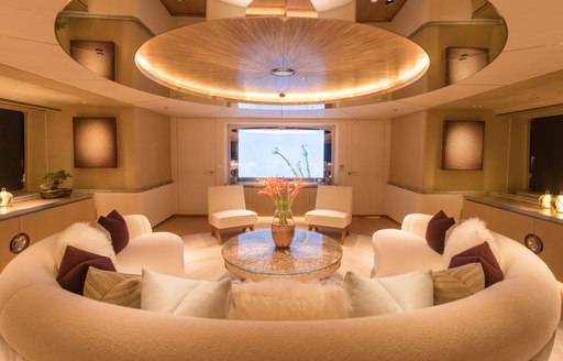 Lounge area on charter yacht DRIFTWOOD with circular sofa and gold light fixture above