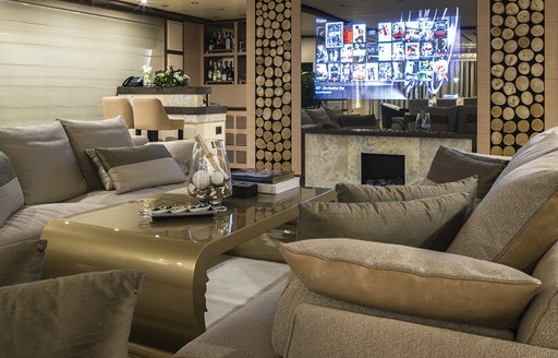 Main salon of motor yacht Soy Amor, with Tv screen and grey sofas