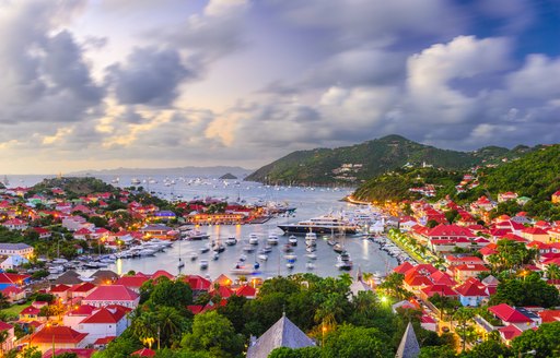 Elevated view looking down on Gustavia Harbor at dusk, with superyacht charters berthed