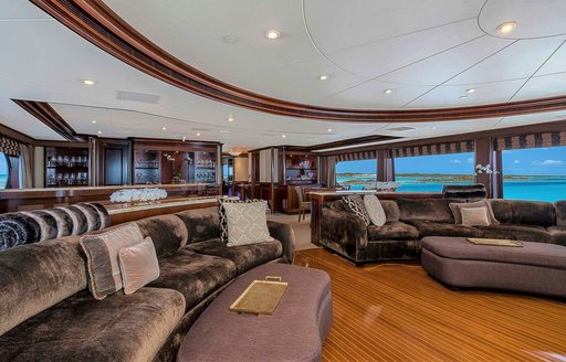 Interior details of luxury motor yacht, with sofa seating and views over Caribbean