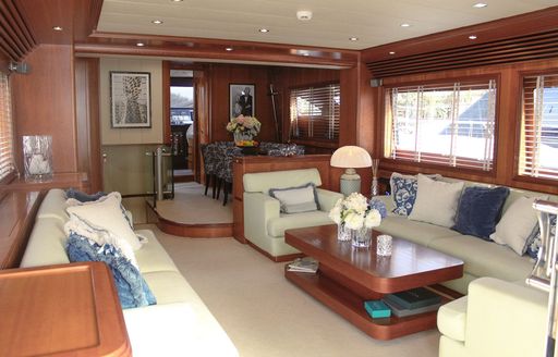 Main salon onboard charter yacht ESSOESS, spacious lounge area in the foreground with dining area aft 