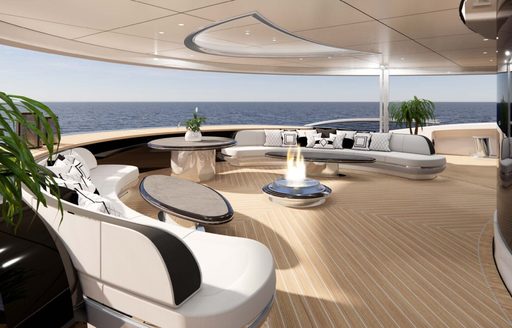 A firepit on the aft deck onboard charter yacht KISMET, surrounded by white seating and a panoramic view of the sea