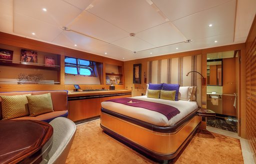 Guest cabin onboard sailing yacht charter MALTESE FALCON, central berth facing forward with a seating area in the foreground
