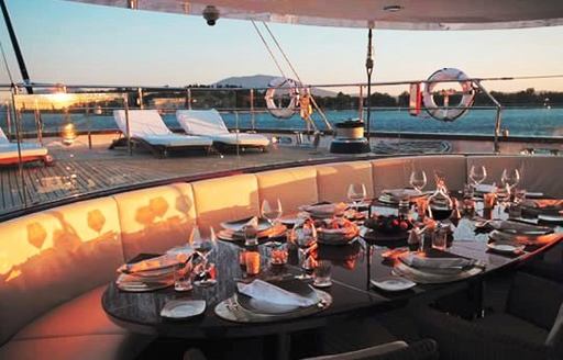 Aft deck dining at sunset on board charter yacht PARSIFAL III