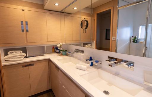 Overview of the bathroom onboard charter yacht SERENISSIMA III, his and hers sinks with large mirrors