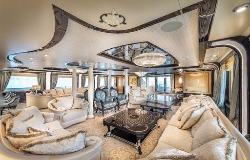 Overview of the main salon onboard charter yacht ELEMENTS, extensive lounge area with white upholstery
