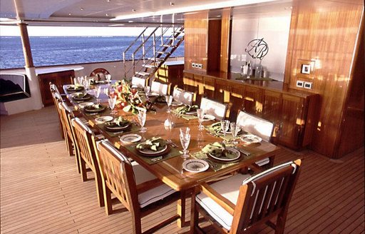 Alfresco dining onboard charter yacht NOMAD, long table set for an evening meal