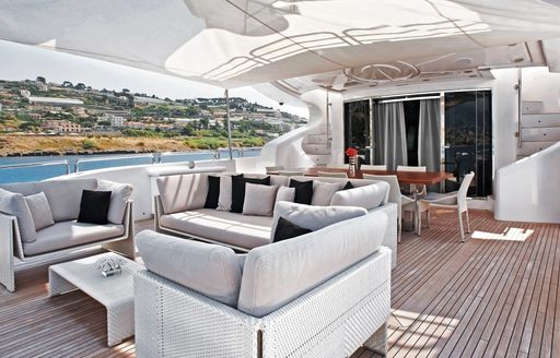 alfresco lounge and dining table on aft deck of superyacht Tutto le Marrané