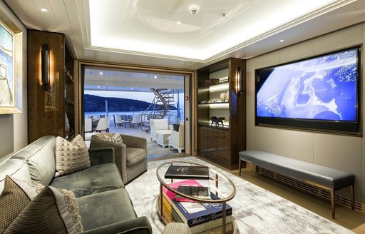 intimate salon on board charter yacht joy with view of exterior deck in foreground and tv on wall