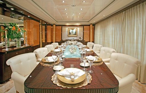 luxury motor yacht LADY LOLA dining salon with classic artworks and comfy chairs 