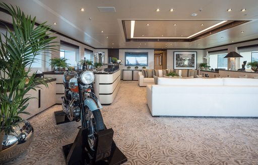 Main salon onboard charter yacht TRIUMPH with a motorcycle in the foreground