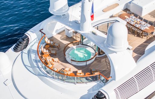 On deck Jacuzzi onboard charter yacht CARINTHIA VII, surrounded by seating and an alfresco dining area aft
