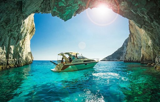 A small yacht in the entrance to the blue caves in Zakynthos, Greece