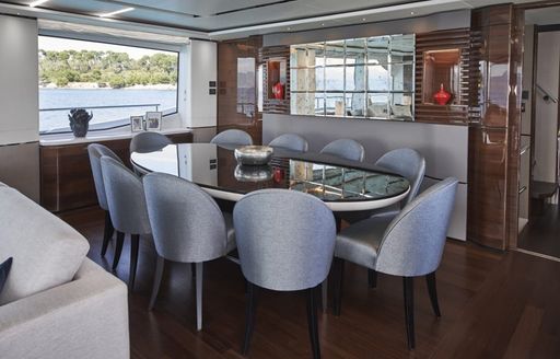 Interior dining area onboard charter yacht ANKA, oval table with grey seating