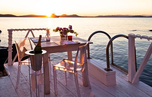 table set for two at Phi Beach, Sardinia, as sun sets