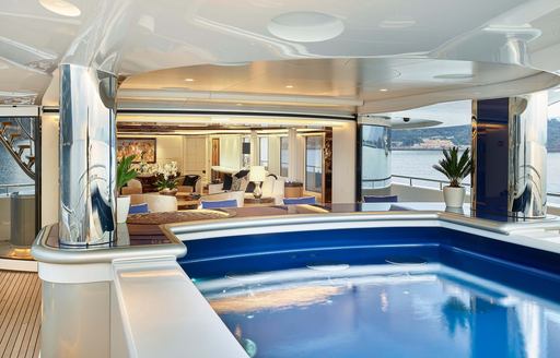 Overview of the swimming pool onboard super yacht charter EXCELLENCE, with seating visible in the background