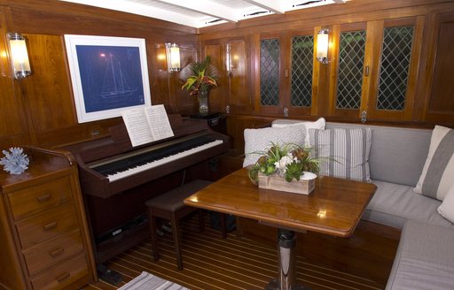 piano and sofas in the main salon aboard charter yacht EROS