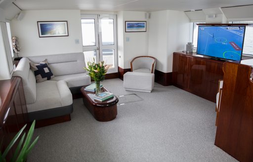 main salon with seating and large TV aboard motor yacht ‘Laura J’ 