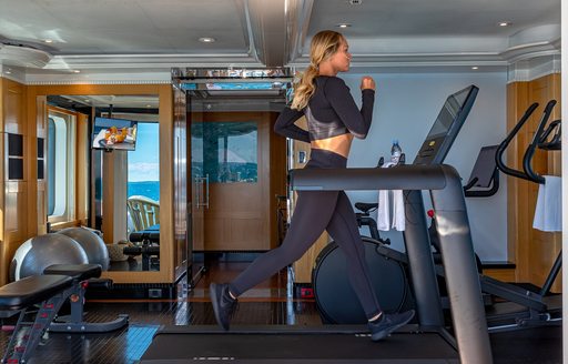 A guest working out in the gym on board charter yacht Marguerite