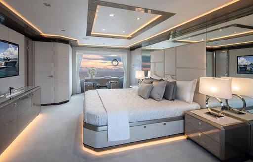Master cabin onboard charter yacht ENTREPRENEUR, central berth facing port opposite a wall mounted TV, with large window in the background