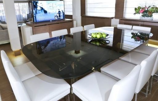 dining table with white chairs in main salon of luxury yacht IPANEMAS 