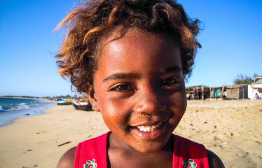 A young black child with amber hair smiles into the camera