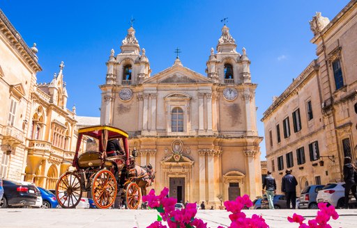 malta cathedral in a square with pink flowers 