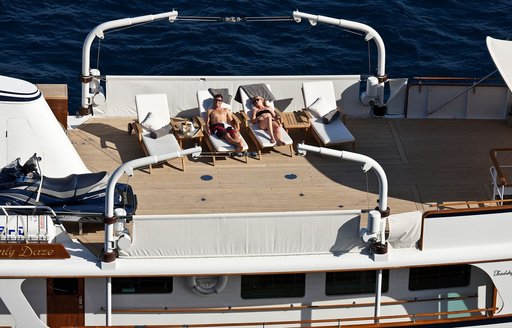 guests recline on sun loungers aboard the sundeck of luxury yacht ‘Heavenly Daze’ 