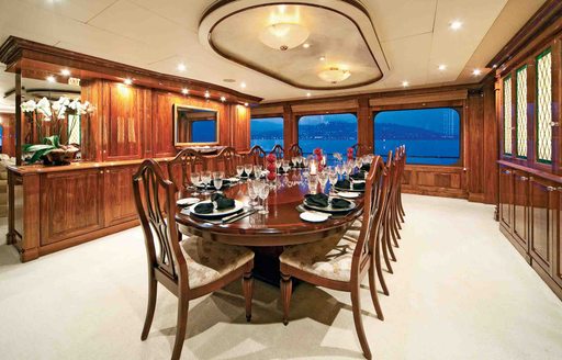 formal dining area with rich wooden wall panels on board motor yacht ‘One More Toy’