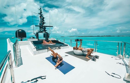 Guests exercising on sundeck of superyacht OCULUS