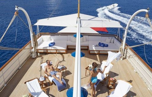 Charter guests enjoying time on the sundeck of luxury yacht MALAHNE