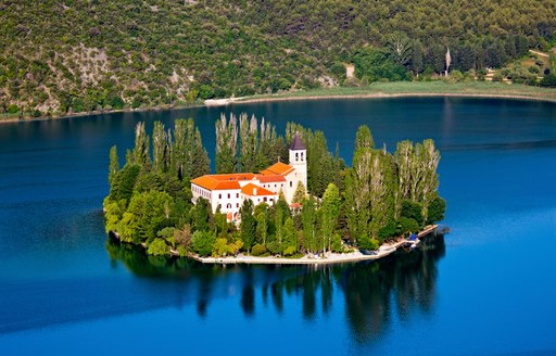 Idyllic island in Croatia with stone monastery in the centre