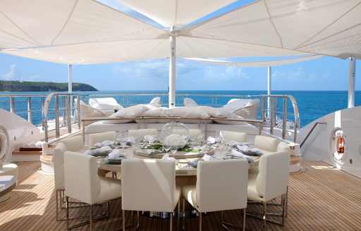 circular alfresco dining table under shade of awnings on sundeck of superyacht ‘Lady Luck’ 