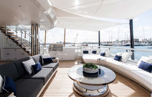 Alfresco lounge area onboard charter yacht RESILIENCE, plush white and gray seating 