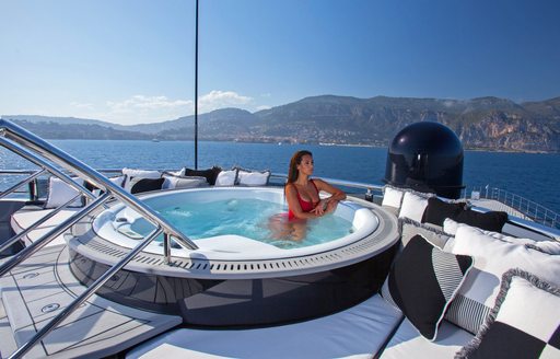 charter guest unwinds in Jacuzzi aboard charter yacht OKTO 