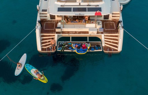 Aerial view looking down at the swim platform on charter yacht SERENISSIMA III, with multiple water toys on the platform and adjacent in the water