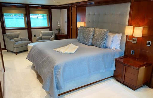 Double bed and windows in background on superyacht Chasing Daylight