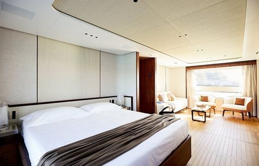 Master cabin onboard charter yacht TOSUN, forward facing berth with seating area aft adjacent to large window