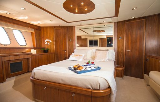 Double guest cabin onboard private yacht charter MEDITERRANI IV, central berth facing forward with large mirrors aft
