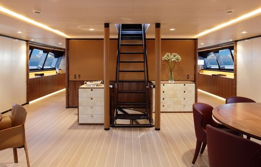 dining area and steal and wenge staircase in the forward section of luxury yacht FIDELIS 