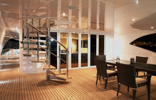 alfresco dining area on upper deck aft at night on board luxury yacht AUSTRALIS 