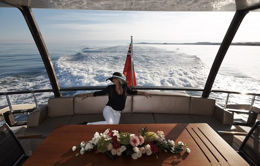 female guest relaxes on main deck aft of superyacht QUANTUM 