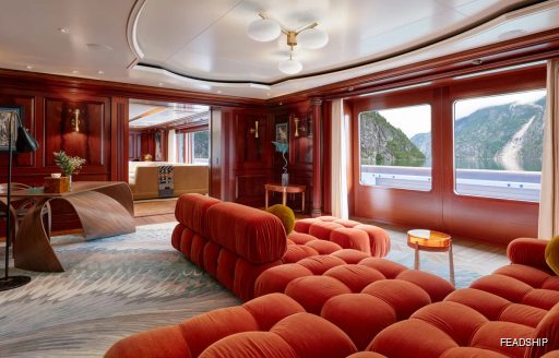 Overview of an interior seating area with wide windows onboard charter yacht FIREBIRD