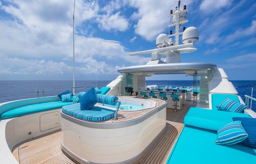 Deck Jacuzzi onboard charter yacht NITA K II, surrounded by blue sun pads and seating