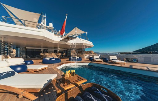 Overview of the swimming pool onboard luxury yacht charter PROJECT X with surrounding sun loungers
