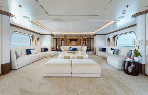 Main salon onboard charter yacht SAMIRA, spacious lounge area with plush white seating and large windows