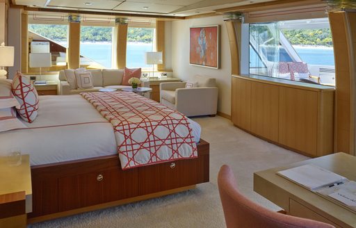 Bed and large windows in master suite on luxury yacht Victoria del Mar