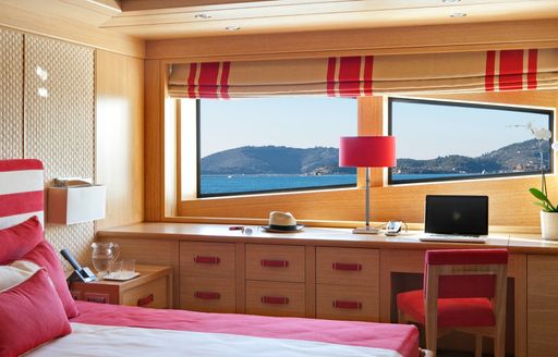 The red and bright wood styling of a cabin on board superyacht Ramble On Rose
